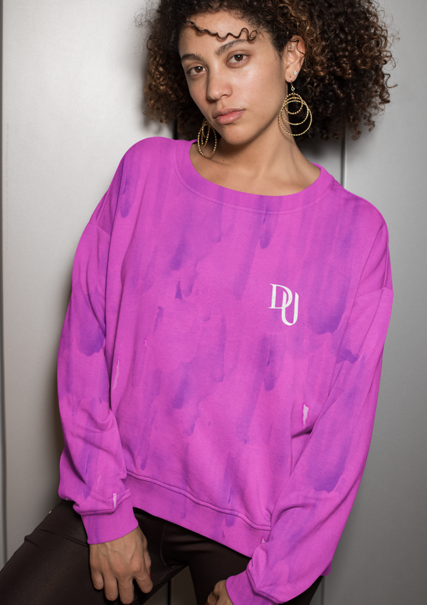 a woman with curly hair wearing a purple sweatshirt