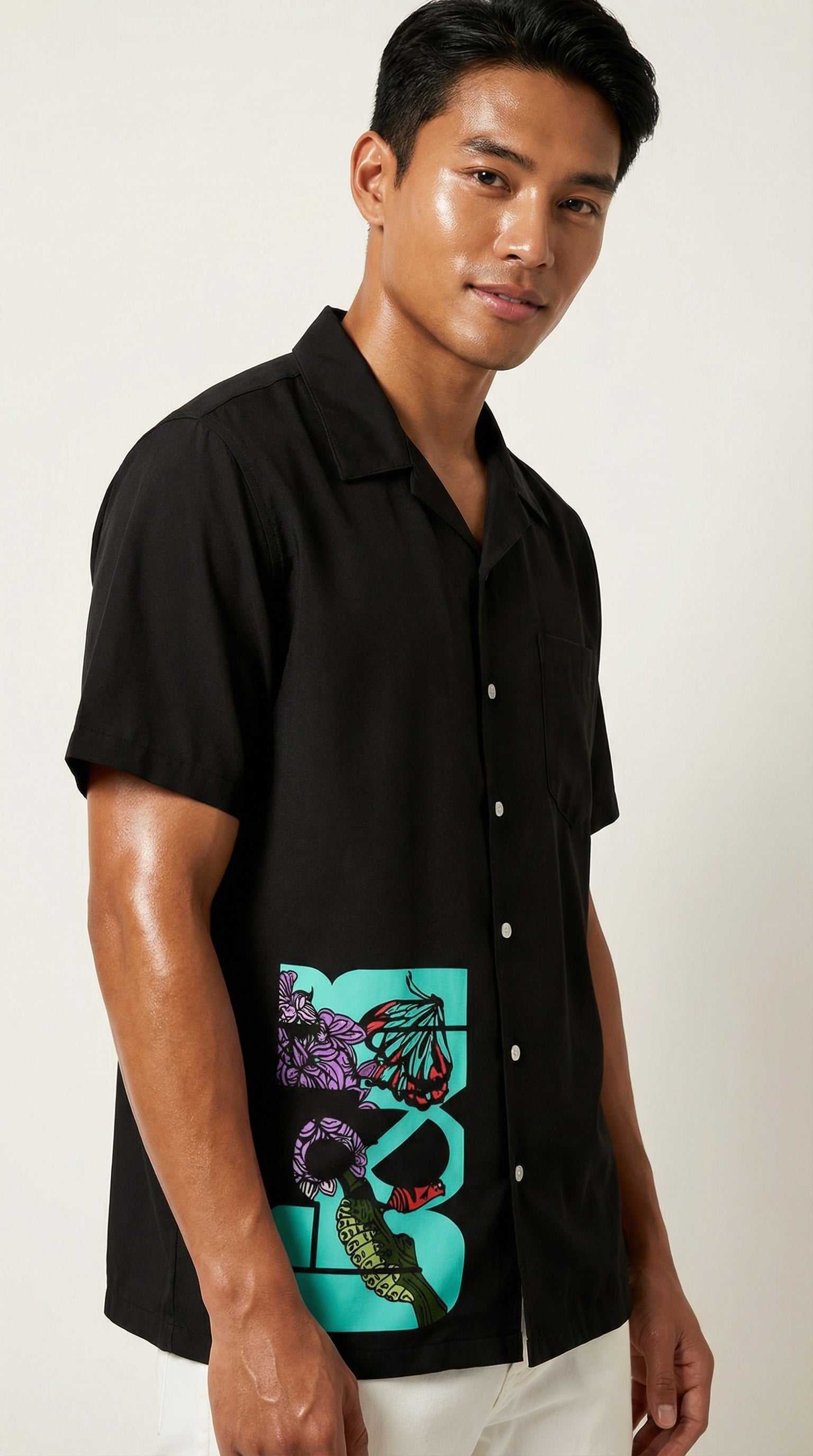 Man wearing a black shirt with a colorful design on a white background