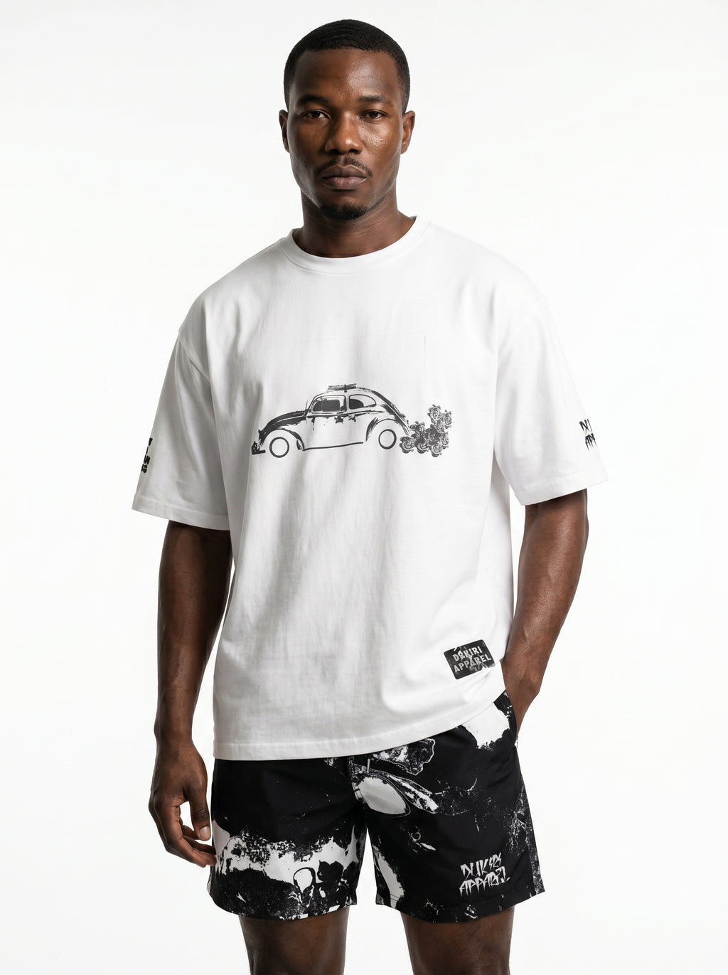 Man wearing a white t-shirt with a graphic design and black shorts on a white background