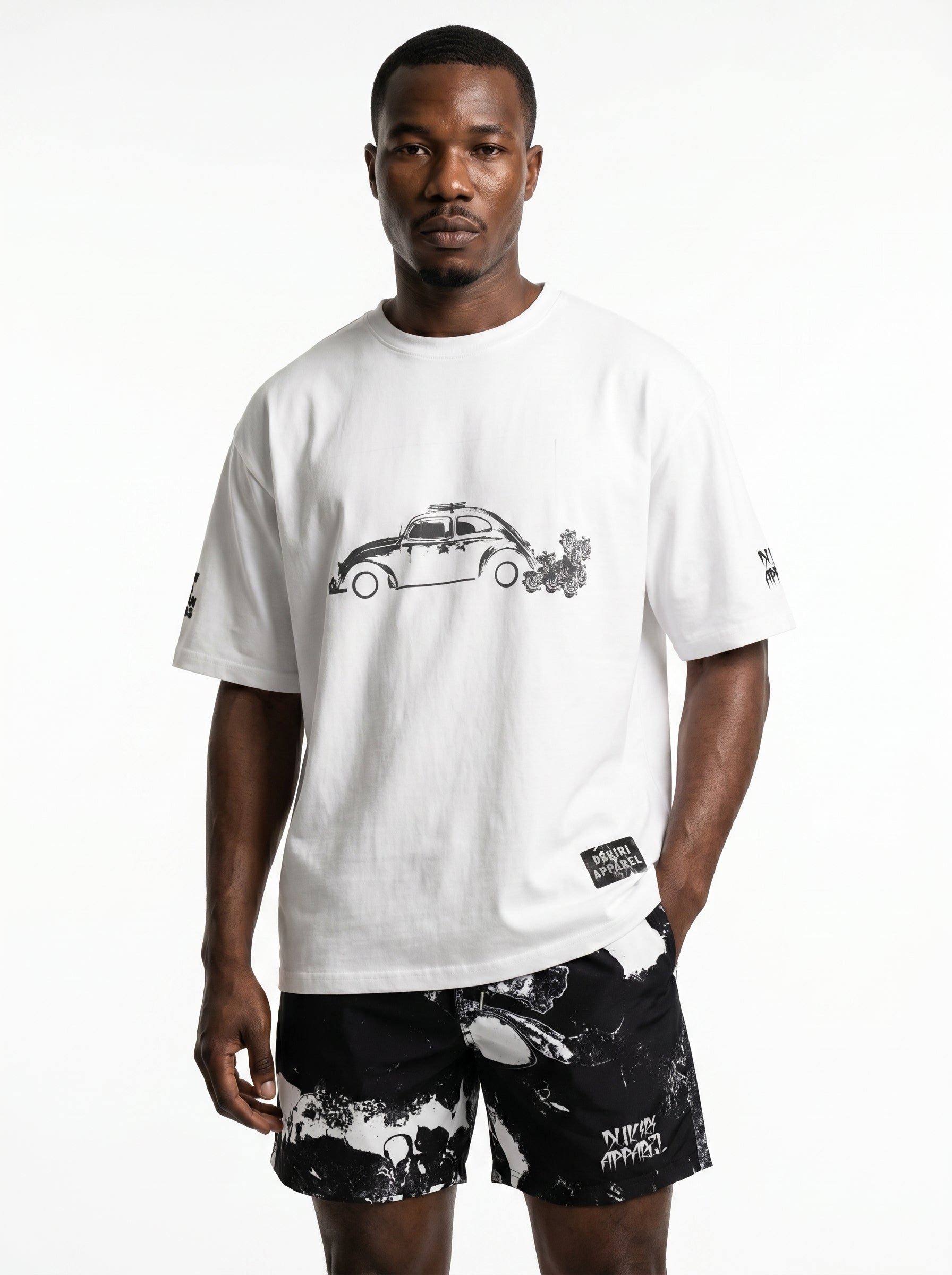 Man wearing a white t-shirt with a graphic design and black shorts on a white background