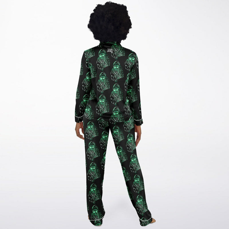 Person wearing a black pajama set with green skull patterns on a white background