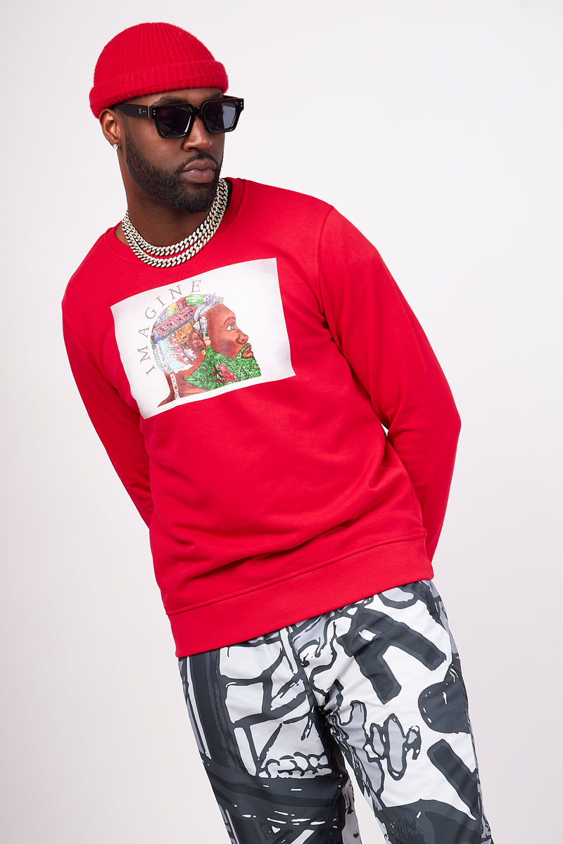 man wearing a red organic cotton sweatshirt with an urban design of a black man with an urban city as his hair. The imaginary man sweatshirt