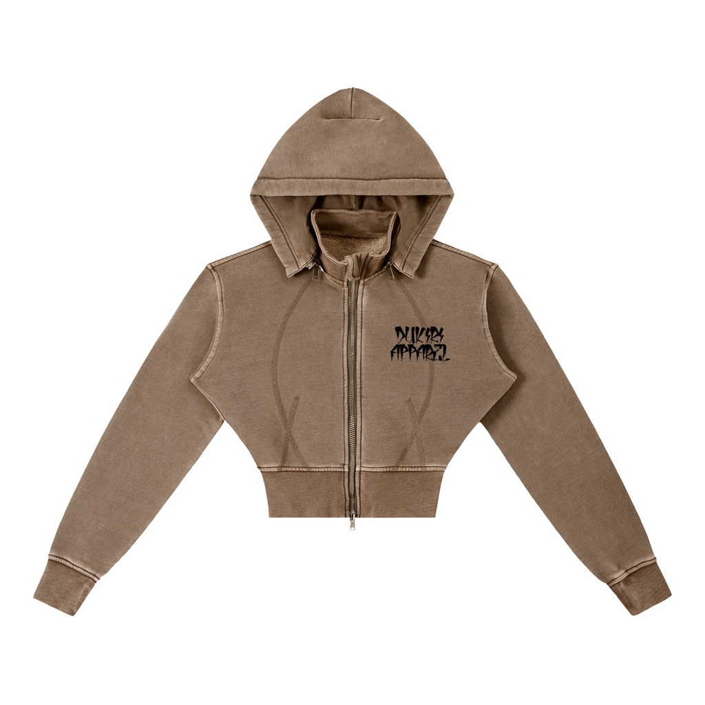 A cropped zip-up hoodie in a washed taupe-brown color, featuring a black graphic text print on the left chest that reads 'DUKIRI APPAREL'. The hoodie has a full front zipper, a hood, and ribbed cuffs and hem, shown against a plain white background.