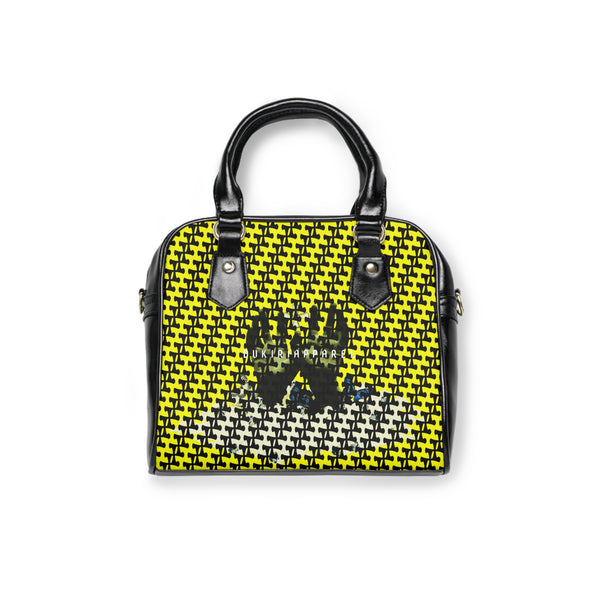 A shoulder handbag with a black and yellow checkered pattern, featuring a graphic of three figures on the front.