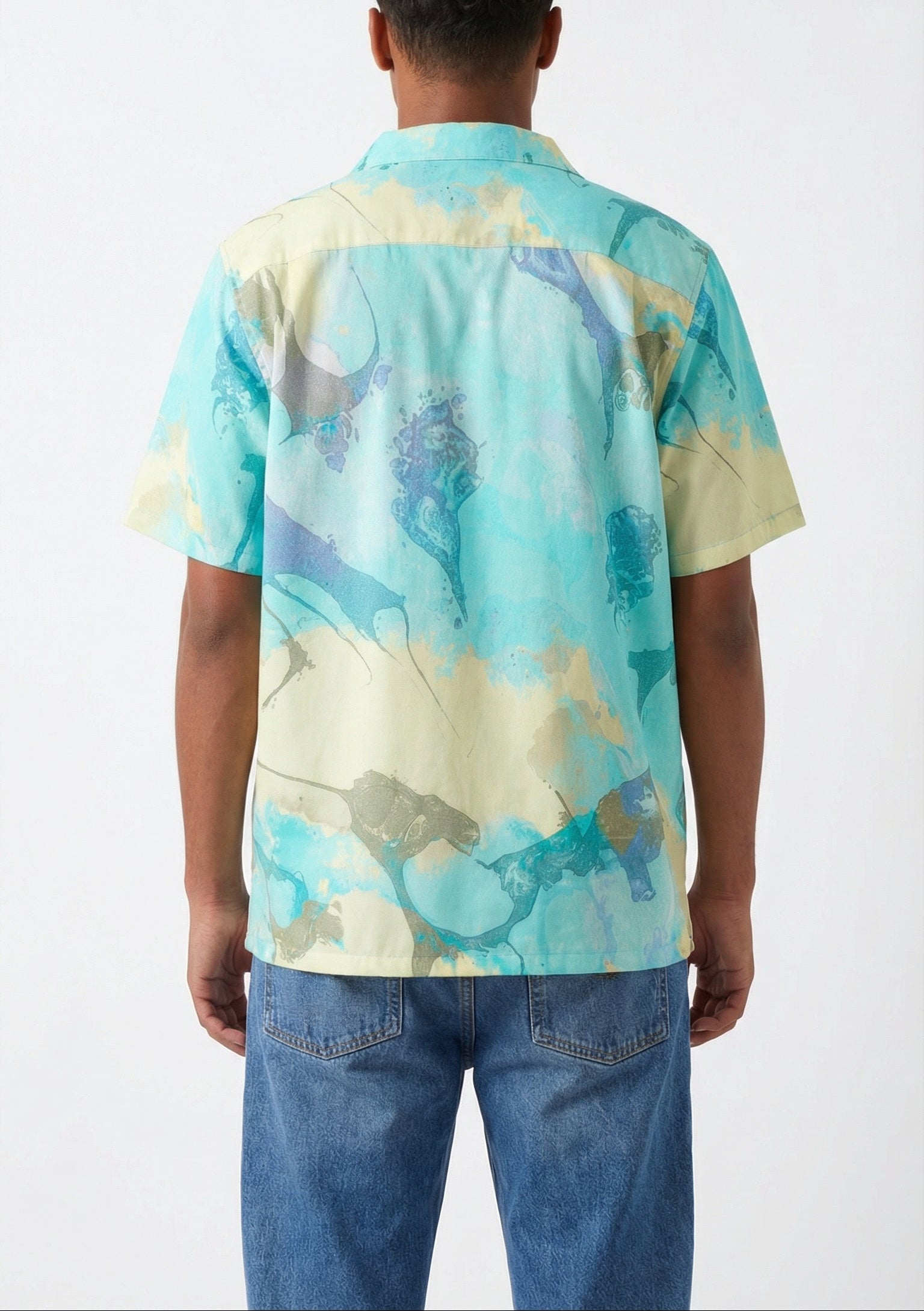Person wearing a tie-dye shirt with abstract patterns on a white background