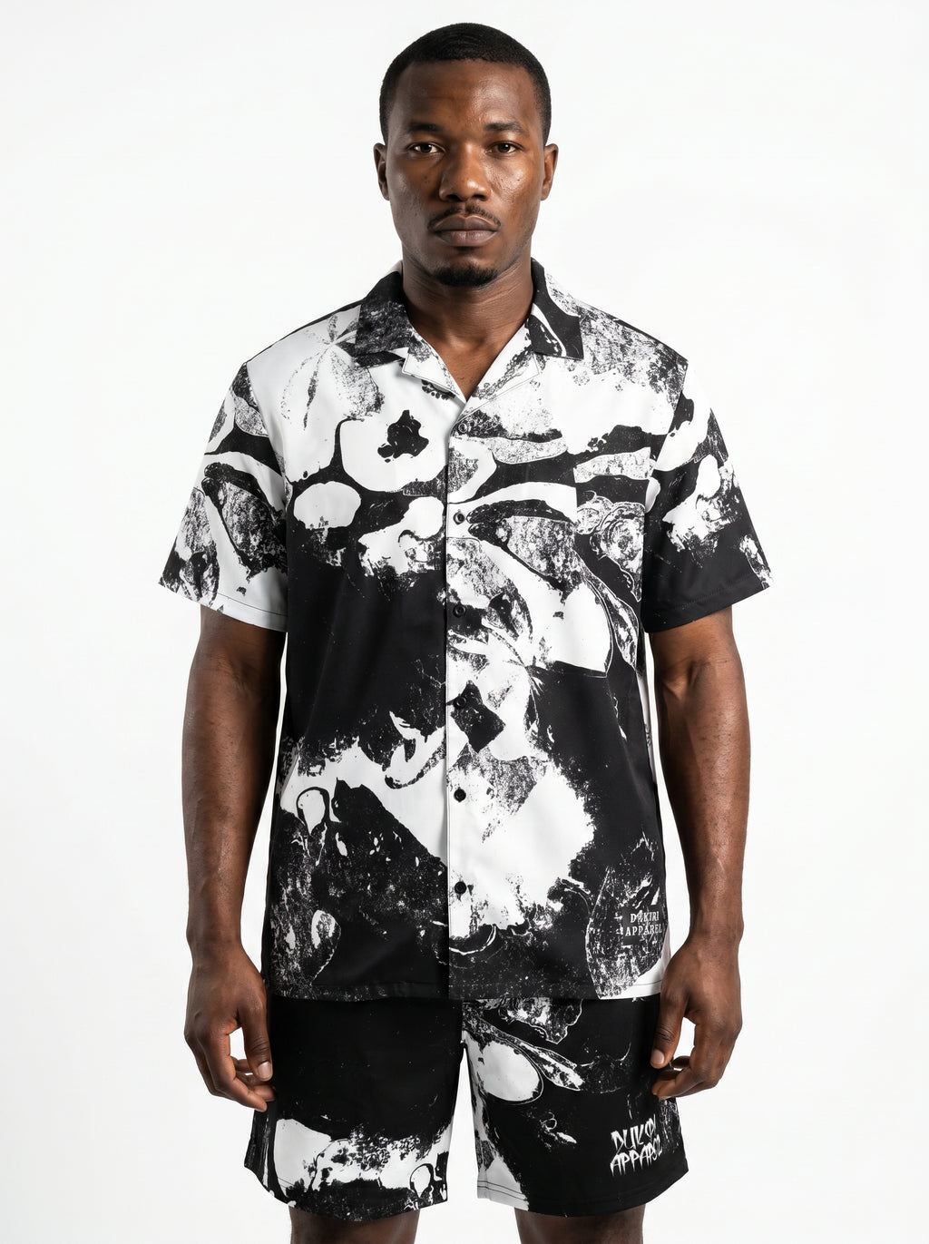 Man wearing a black and white patterned shirt on a white background