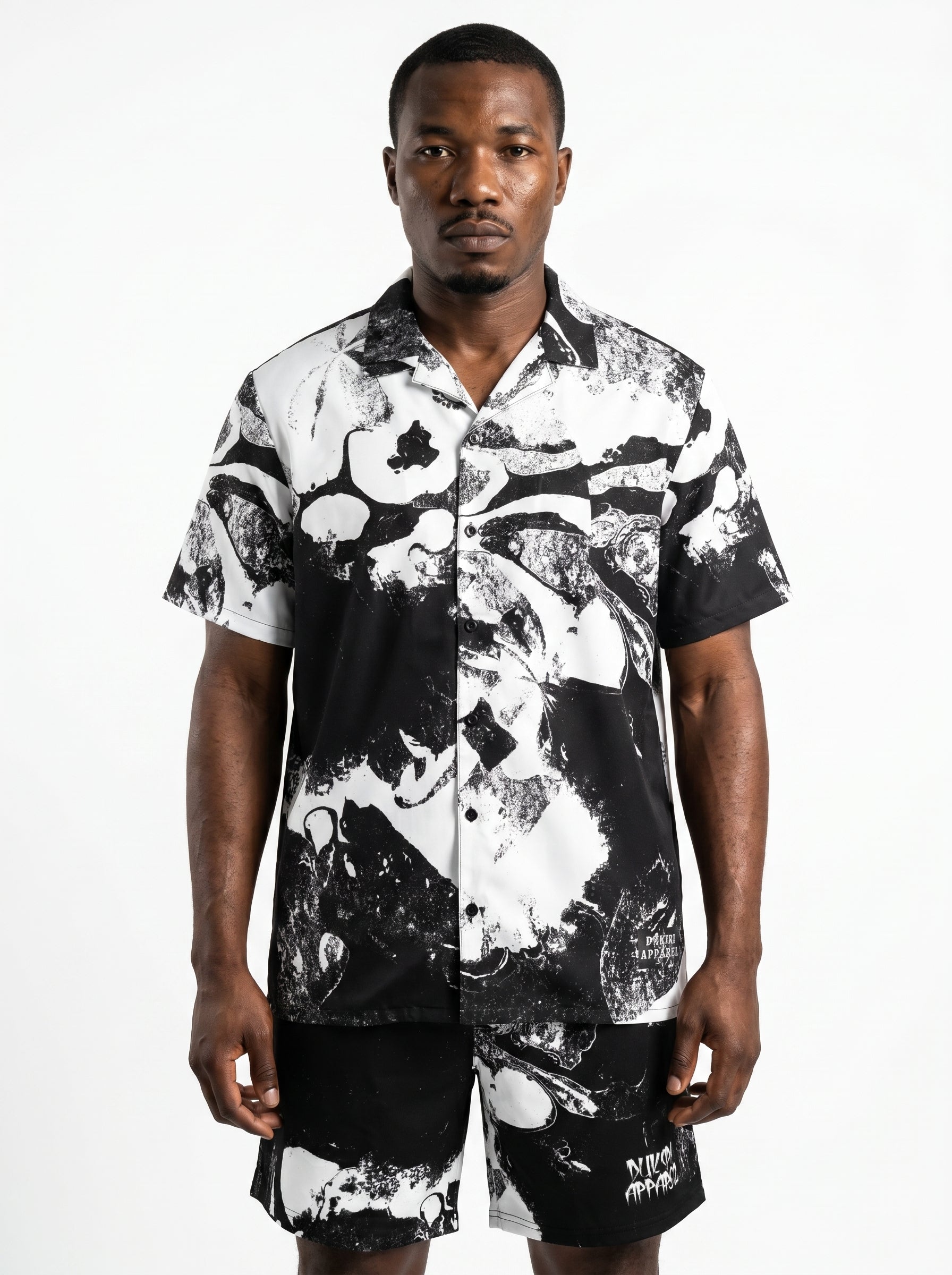 Man wearing a black and white patterned shirt on a white background