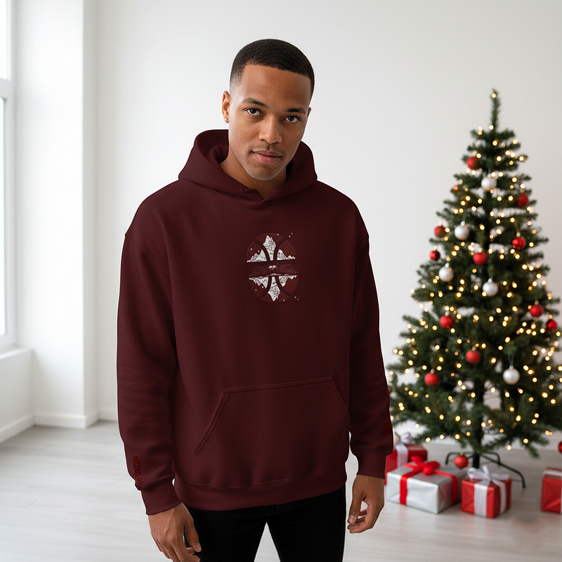 Man wearing a maroon hoodie with a Christmas tree and presents in the background