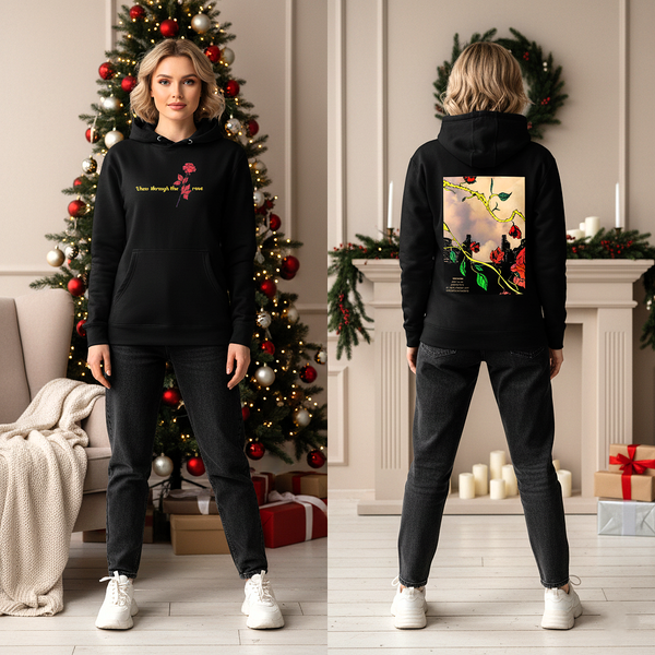 Person wearing a black hoodie with a design on the front and back, standing in a decorated room with Christmas tree and fireplace.
