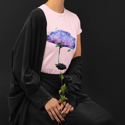 Woman wearing a beautiful floral design that is purple in color with some small leaves that are white. The t-shirt is pink and  is from Dukiriapparel