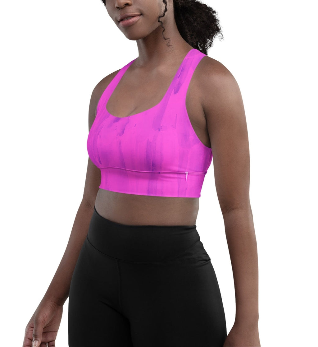 A woman wearing a purple longline sports bra with double-layered front straps and a mesh lining.